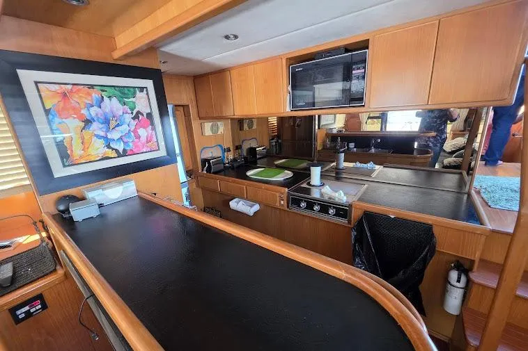 Slide: The Image of Interior of 1993 McKinna 48 Pilothouse yacht with modern kitchen and vibrant artwork. - 22
