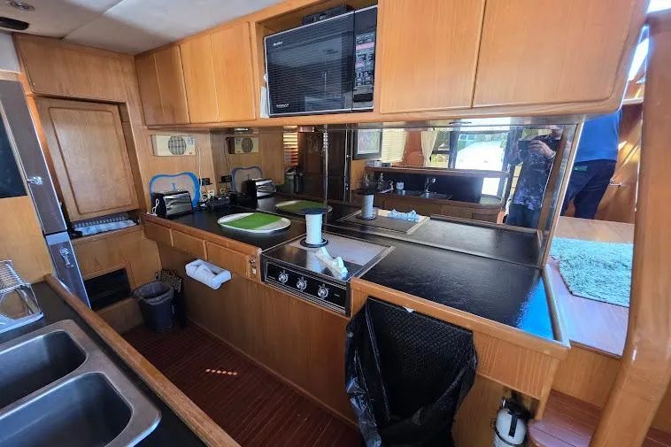Slide: The Image of 1993 McKinna 48 Pilothouse kitchen with wood cabinetry, stove, and microwave. - 23