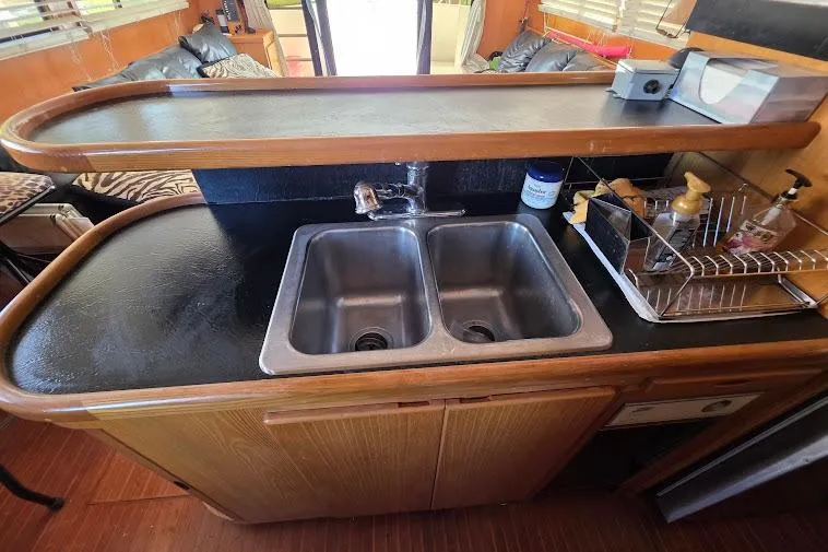 Slide: The Image of 1993 McKinna 48 Pilothouse kitchen with dual sinks and wooden cabinetry. - 26