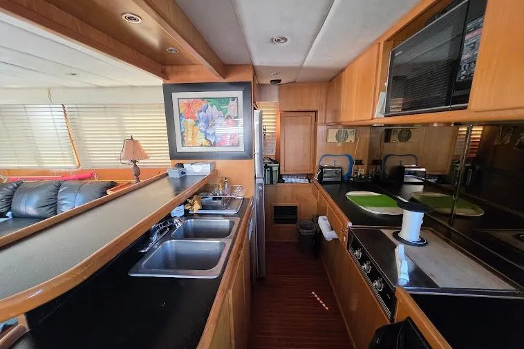 Slide: The Image of Luxurious 1993 McKinna 48 Pilothouse yacht kitchen with modern amenities and elegant wood finishes. - 31