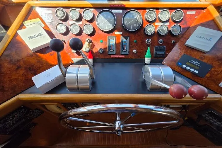 Slide: The Image of 1993 McKinna 48 Pilothouse helm with gauges, controls, and steering wheel. - 42