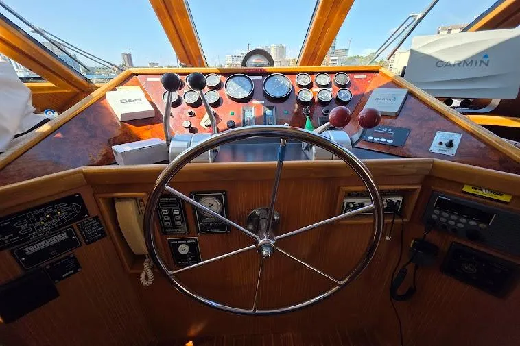 Slide: The Image of 1993 McKinna 48 Pilothouse helm with steering wheel, gauges, and navigation equipment. - 43