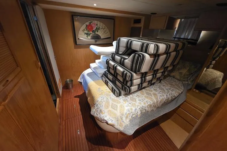 Slide: The Image of Interior of 1993 McKinna 48 Pilothouse with stacked cushions on bed. - 47
