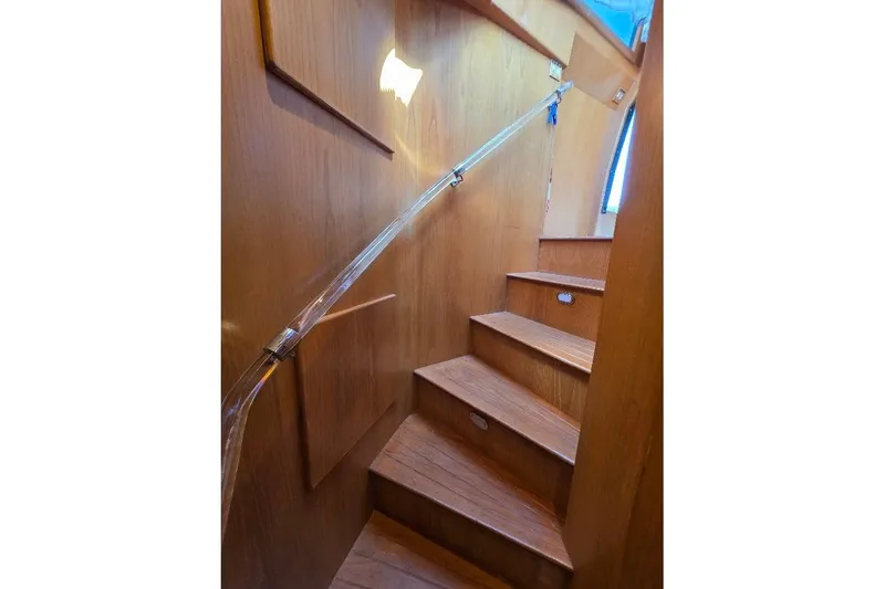 Slide: The Image of Wooden staircase inside 1993 McKinna 48 Pilothouse yacht, featuring sleek handrail design. - 48