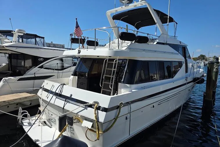 Slide: The Image of 1993 McKinna 48 Pilothouse yacht docked at marina, featuring sleek design and American flag. - 5