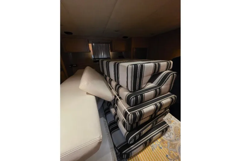 Slide: The Image of Cushions stacked inside 1993 McKinna 48 Pilothouse, featuring striped upholstery. - 52