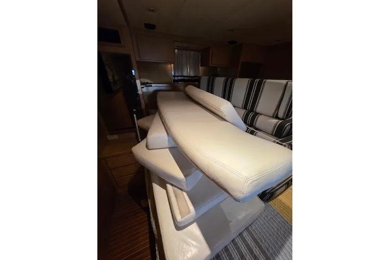 Slide: The Image of Interior of 1993 McKinna 48 Pilothouse with stacked cushions and striped seating. - 53