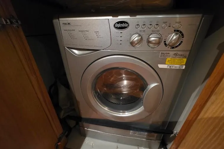 Slide: The Image of Splendide washing machine inside a 1993 McKinna 48 Pilothouse yacht's wooden cabinet. - 55