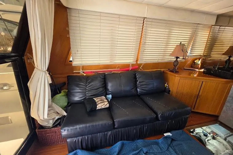 Slide: The Image of Interior of 1993 McKinna 48 Pilothouse with black leather sofa and wooden cabinetry. - 61