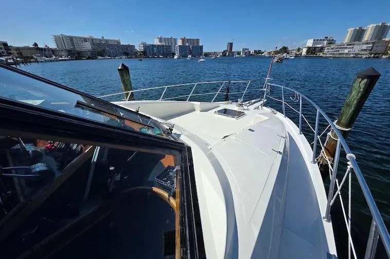 Slide: The Image of 1993 McKinna 48 Pilothouse yacht on water with city skyline in background. - 63