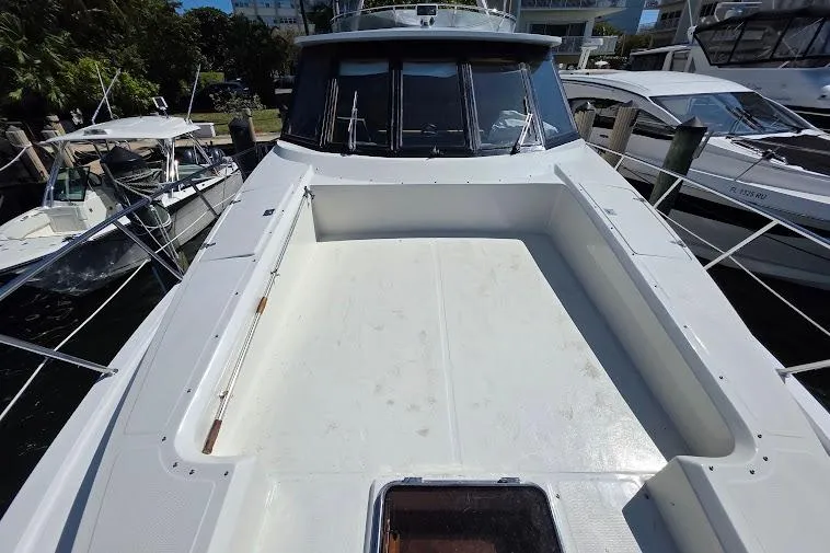 Slide: The Image of 1993 McKinna 48 Pilothouse yacht docked, showcasing spacious deck and sleek design. - 66