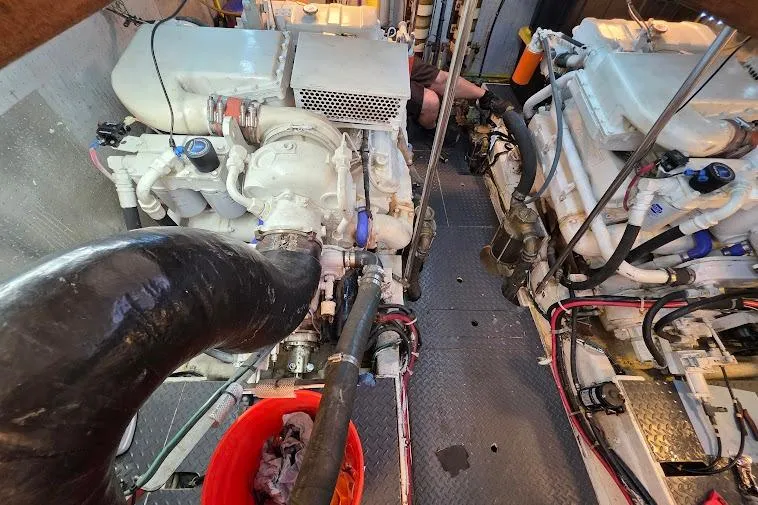 Slide: The Image of Engine room of a 1993 McKinna 48 Pilothouse yacht, showcasing dual engines and mechanical components. - 70