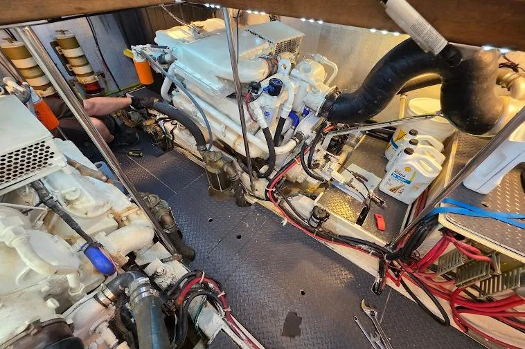Slide: The Image of Engine room of a 1993 McKinna 48 Pilothouse yacht, showcasing mechanical components and wiring. - 71