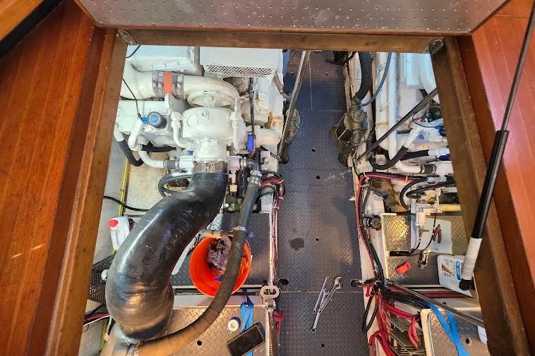 Slide: The Image of Engine room of a 1993 McKinna 48 Pilothouse, featuring mechanical components and tools. - 76