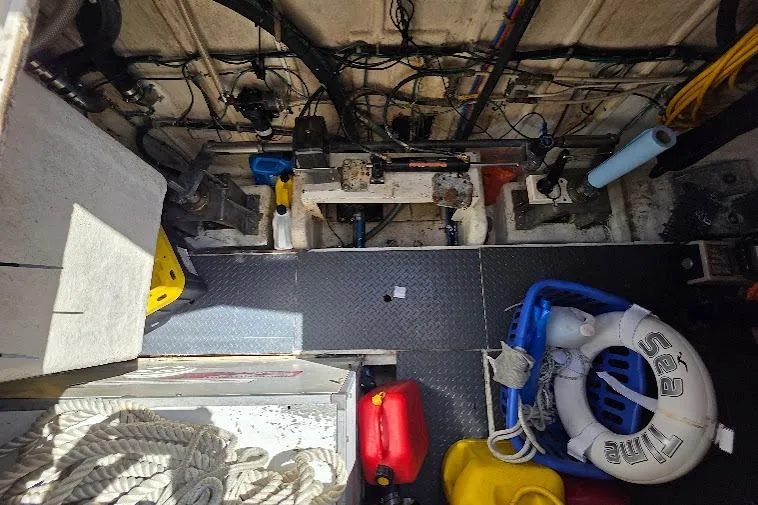Slide: The Image of Engine room of a 1993 McKinna 48 Pilothouse with equipment and safety gear. - 77
