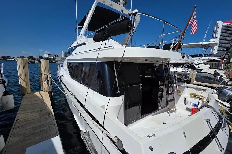 Slide: The Image of 1993 McKinna 48 Pilothouse yacht docked at marina with American flag. - 8