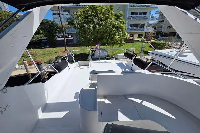 Slide: The Image of 1993 McKinna 48 Pilothouse yacht deck with seating, docked near waterfront buildings. - 84