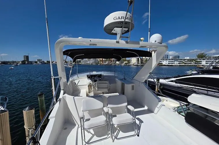 Slide: The Image of 1993 McKinna 48 Pilothouse yacht docked, featuring spacious deck and modern navigation equipment. - 86