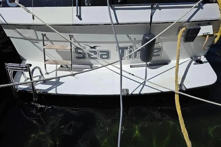 Slide: The Image of 1993 McKinna 48 Pilothouse yacht named "Sea Time" docked with ropes and ladder. - 9