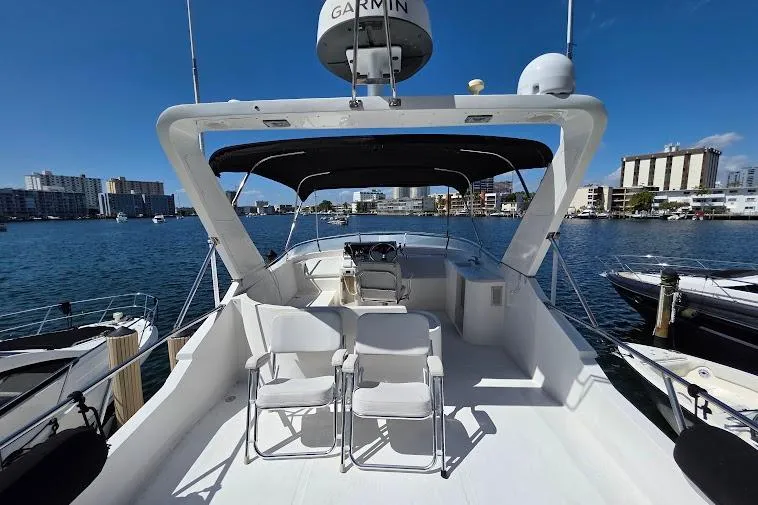 Slide: The Image of 1993 McKinna 48 Pilothouse yacht with spacious deck, docked in a marina under clear blue skies. - 91