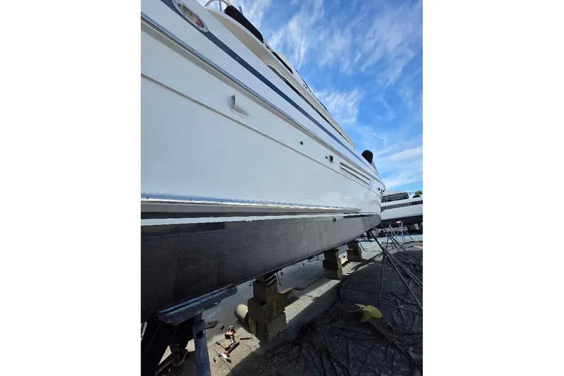 Slide: The Image of 1993 McKinna 48 Pilothouse yacht on dry dock under clear blue sky. - 98
