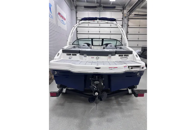 Slide: The Image of 2026 Chaparral 21 SSi boat in showroom, rear view with outboard motor. - 11