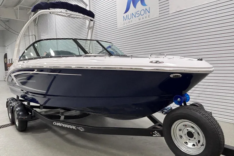 Slide: The Image of 2026 Chaparral 21 SSi boat on trailer in showroom, Munson Surf Wake sign visible. - 5
