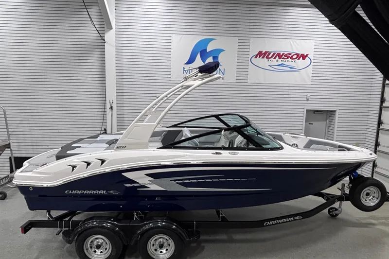 Slide: The Image of 2026 Chaparral 21 SSi boat in showroom, sleek design, blue and white color scheme. - 6