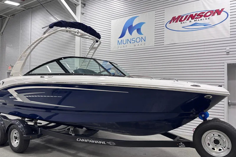 Slide: The Image of 2026 Chaparral 21 SSi boat in showroom, blue hull, Munson Surf & Wake signage. - 10