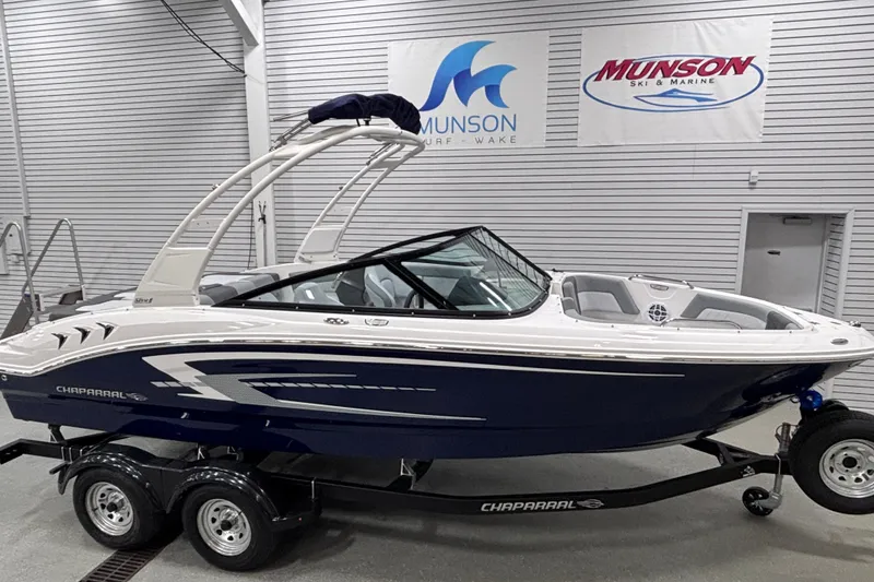 Slide: The Image of 2026 Chaparral 21 SSi boat on trailer in showroom, Munson Ski & Marine banners visible. - 7