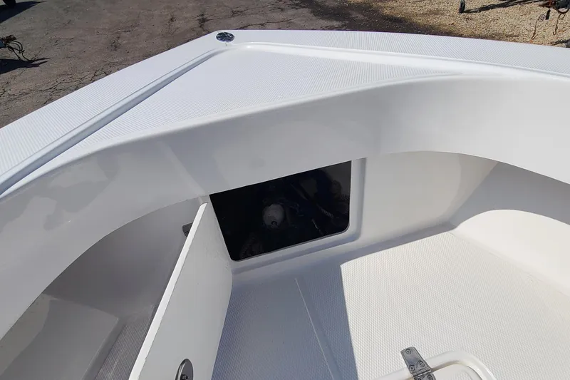 Slide: The Image of 2025 Paramount 21 boat interior with open storage compartment, white deck, and textured surface. - 13