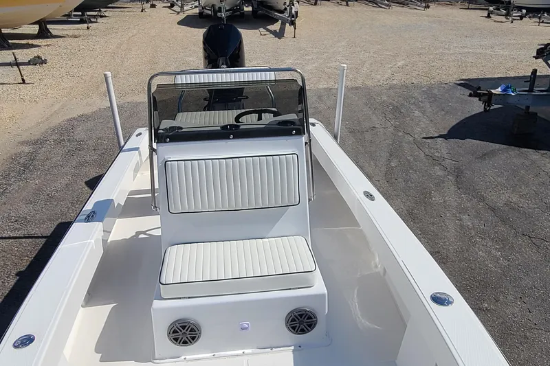 Slide: The Image of 2025 Paramount 21 boat with white seating and console, parked on gravel lot. - 14