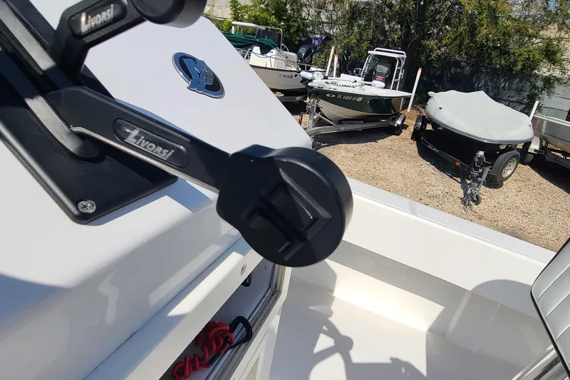 Slide: The Image of Boat control lever on a 2025 Paramount 21, with other boats in the background. - 21