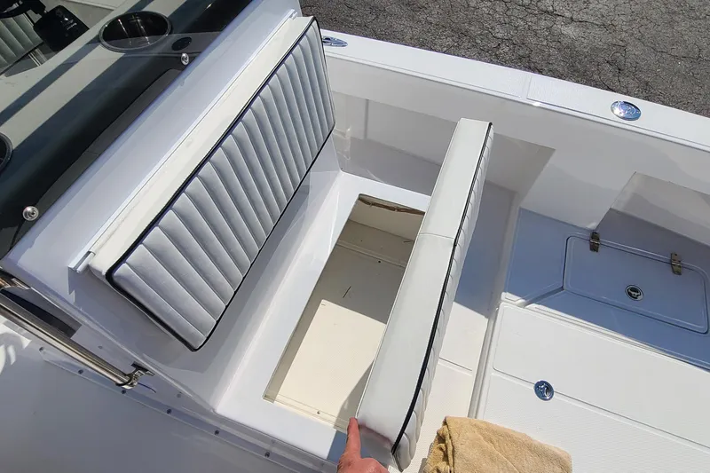 Slide: The Image of 2025 Paramount 21 boat interior with white cushioned seating and storage compartment. - 23