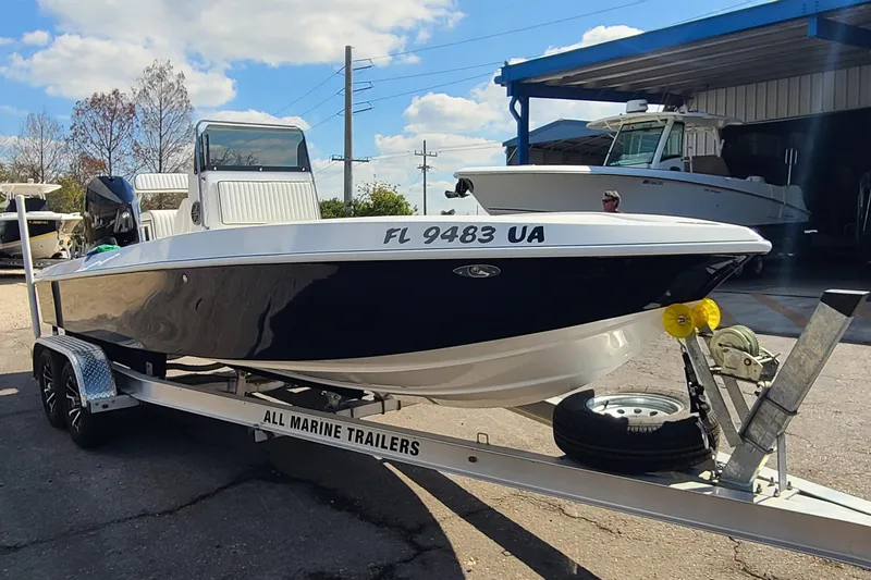 Slide: The Image of 2025 Paramount 21 boat on trailer, parked outdoors under a clear sky. - 3