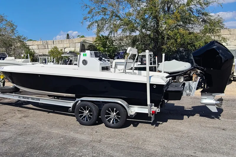 Slide: The Image of 2025 Paramount 21 boat on trailer, parked outdoors, featuring sleek black and white design. - 9