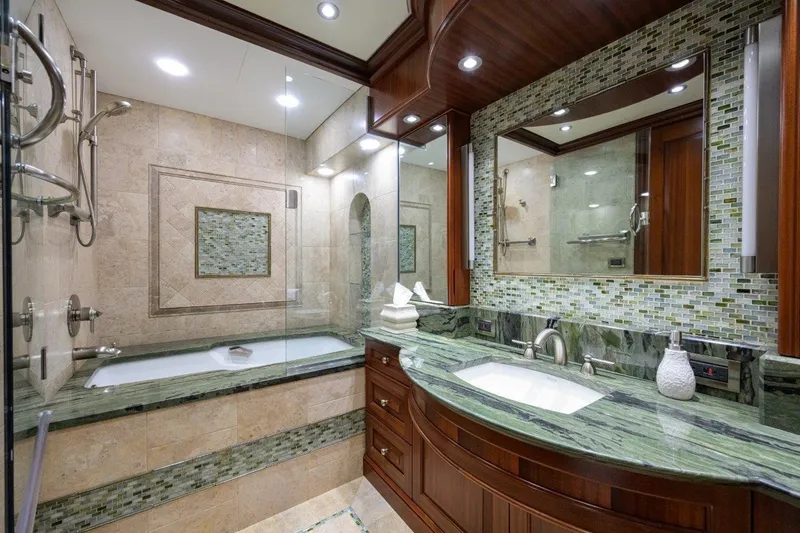 Slide: The Image of Luxurious yacht bathroom with green marble, glass shower, and elegant wood cabinetry, C & G Boatworks Explorer 2011. - 59