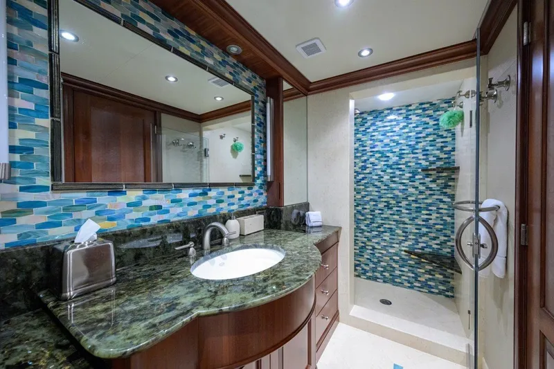 Slide: The Image of Luxurious yacht bathroom with mosaic tiles, granite countertop, and glass shower in 2011 C & G Boatworks Explorer. - 64