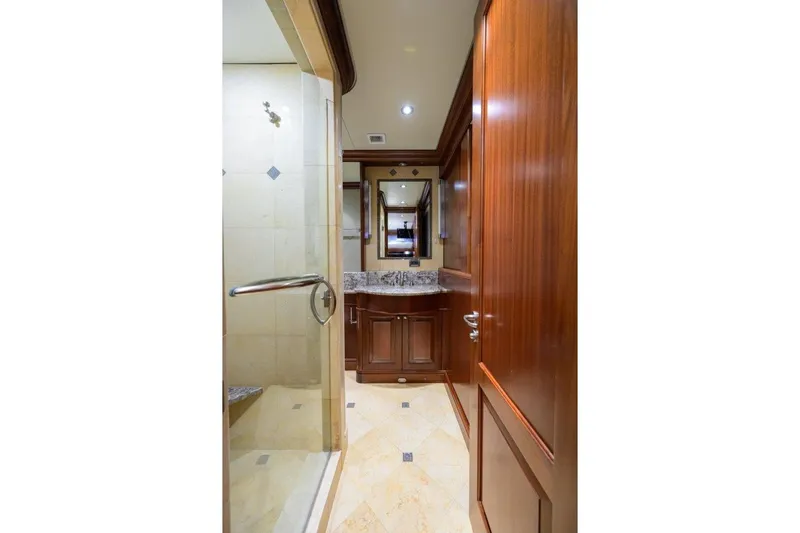 Slide: The Image of Luxurious bathroom interior of 2011 C & G Boatworks Explorer yacht, featuring wood cabinetry and marble accents. - 69