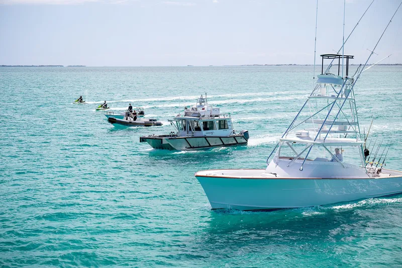 Slide: The Image of Boats and jet skis on turquoise water, featuring a 2011 C & G Boatworks Explorer. - 90