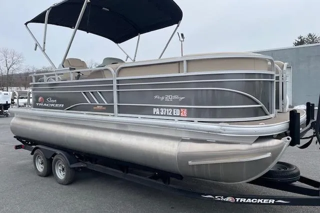 Slide: The Image of 2023 Sun Tracker Party Barge 20 DLX pontoon boat on trailer, side view. - 2