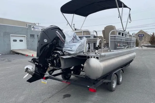 Slide: The Image of 2023 Sun Tracker Party Barge 20 DLX pontoon boat on trailer, outdoor setting. - 3