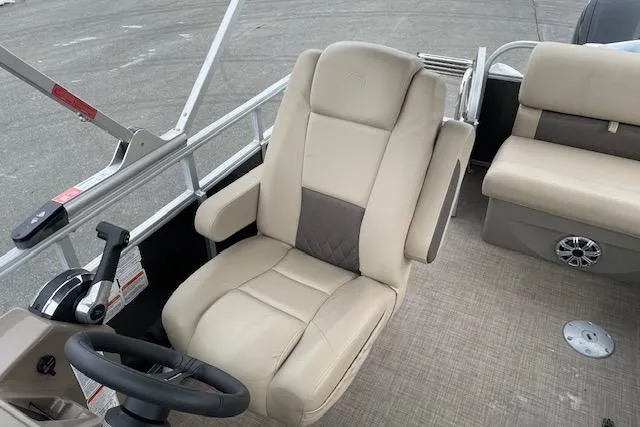 Slide: The Image of 2023 Sun Tracker Party Barge 20 DLX captain's chair and helm, featuring beige upholstery. - 7