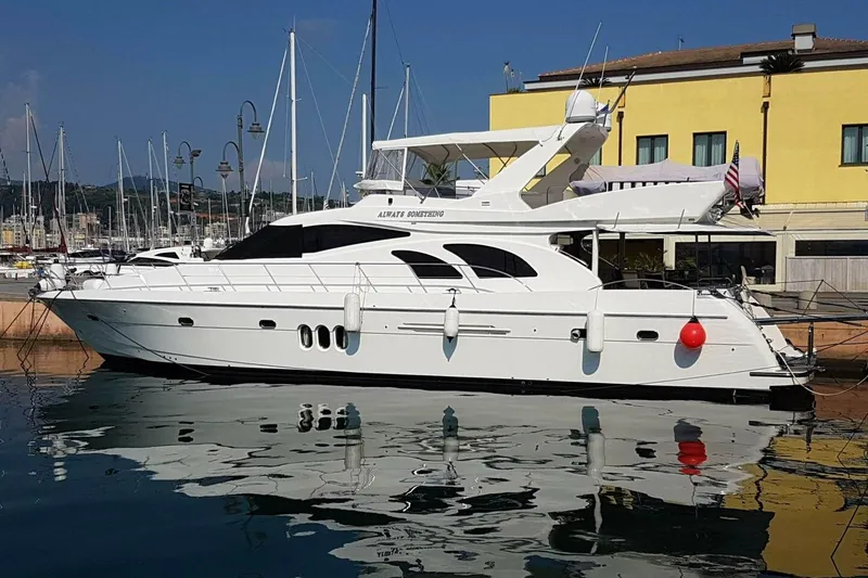 Slide: The Image of 2009 Grand Harbour 66 Motoryacht docked at marina, reflecting on calm water. - 1