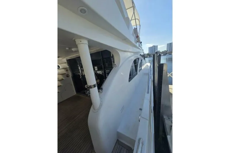 Slide: The Image of 2009 Grand Harbour 66 Motoryacht docked, showcasing sleek design and spacious deck area. - 10