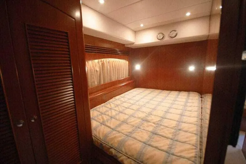 Slide: The Image of Luxurious bedroom in 2009 Grand Harbour 66 Motoryacht with wood paneling and cozy lighting. - 17