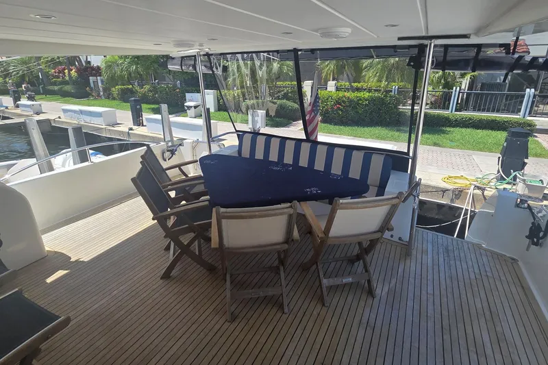 Slide: The Image of Outdoor seating area on 2009 Grand Harbour 66 Motoryacht with wooden deck and striped cushions. - 36