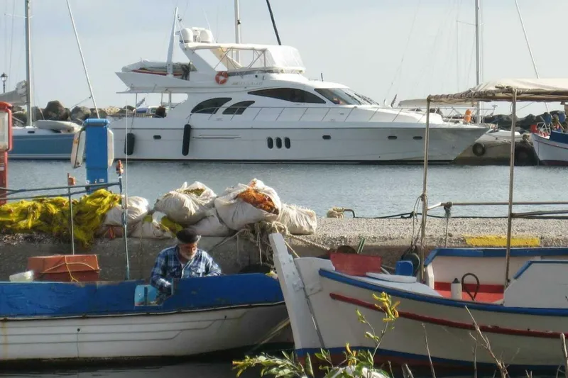Slide: The Image of 2009 Grand Harbour 66 Motoryacht docked near fishing boats and nets in a marina. - 4