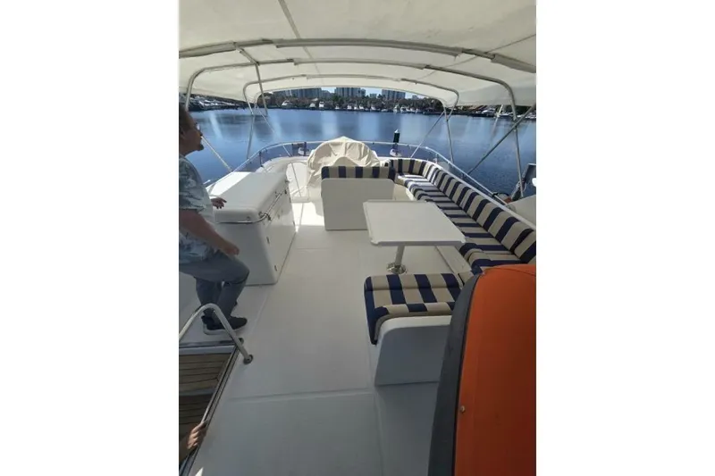 Slide: The Image of 2009 Grand Harbour 66 Motoryacht deck with striped seating and table, overlooking water. - 7