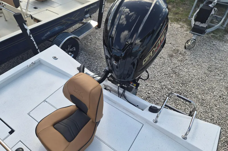 Slide: The Image of 2026 Xpress H24B Bay boat with tan seat and powerful outboard motor. - 12